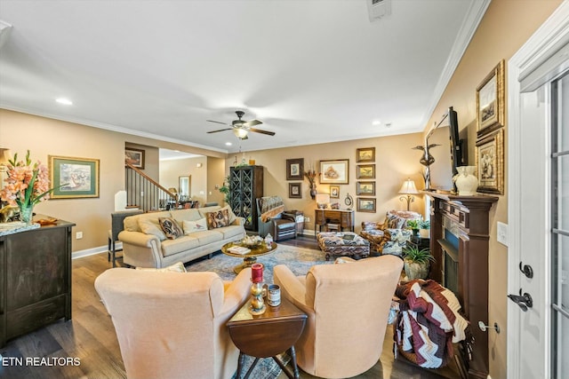 living room featuring ceiling fan, dark wood-type flooring, and crown molding