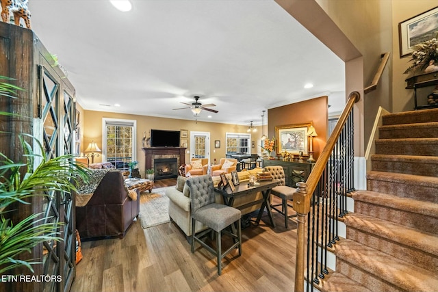 living room featuring ceiling fan, hardwood / wood-style floors, and ornamental molding