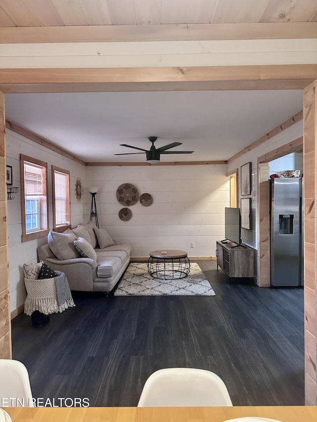 unfurnished living room featuring ceiling fan, dark hardwood / wood-style flooring, and wooden walls