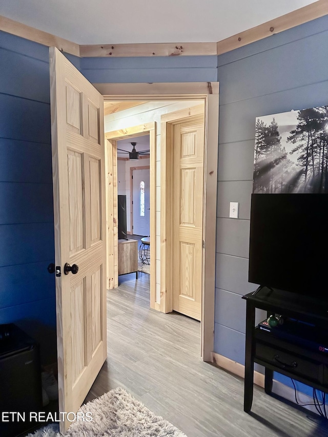 hallway featuring hardwood / wood-style floors and wood walls