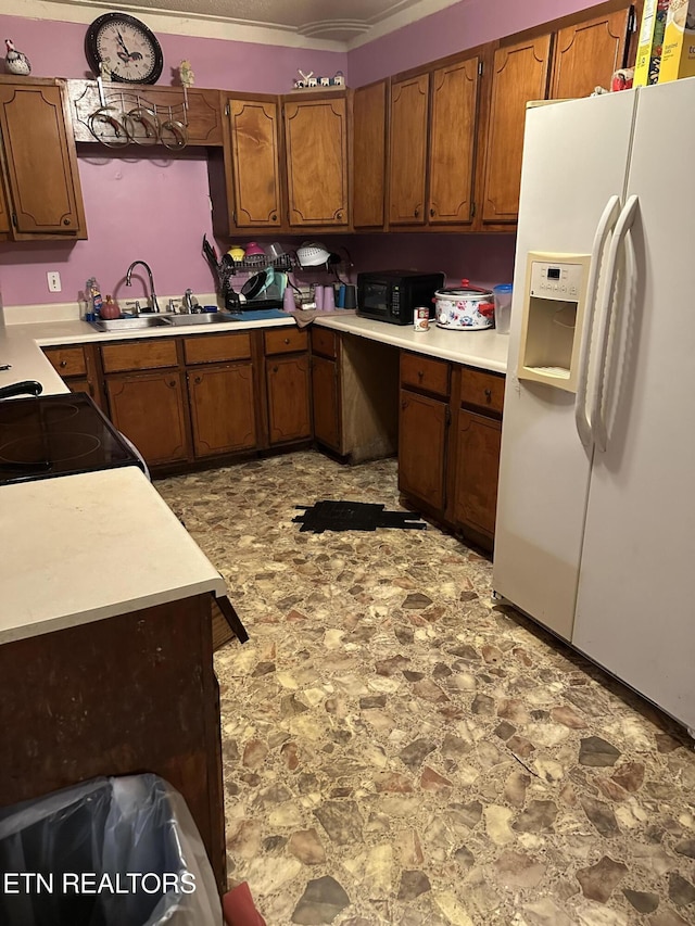 kitchen with electric stove, sink, and white refrigerator with ice dispenser