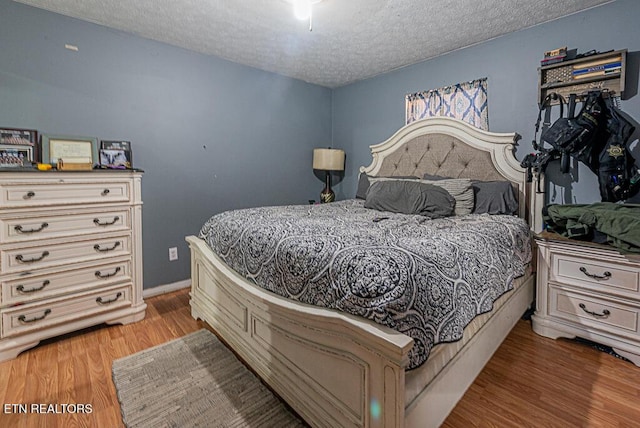 bedroom with wood-type flooring and a textured ceiling