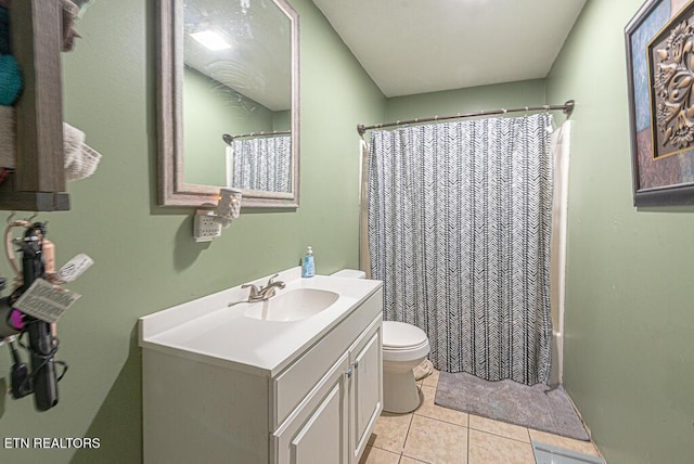 bathroom with toilet, tile patterned floors, and vanity