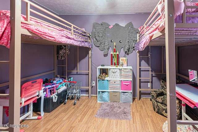 bedroom featuring wood-type flooring and a textured ceiling