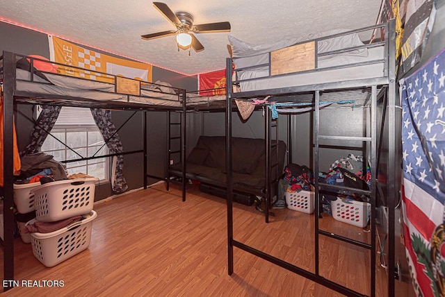 bedroom featuring hardwood / wood-style flooring, a textured ceiling, and ceiling fan