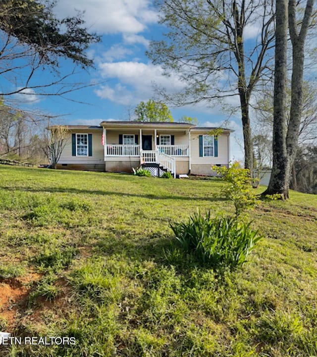 ranch-style home featuring a front lawn and a porch