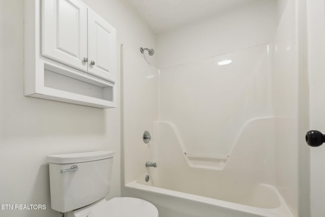 bathroom featuring shower / tub combination and toilet