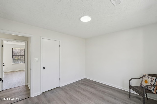 spare room with hardwood / wood-style floors and a textured ceiling