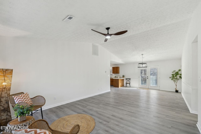 living room with vaulted ceiling, ceiling fan, and light hardwood / wood-style flooring