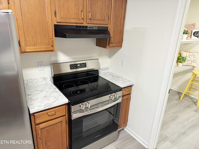 kitchen featuring appliances with stainless steel finishes and light hardwood / wood-style flooring