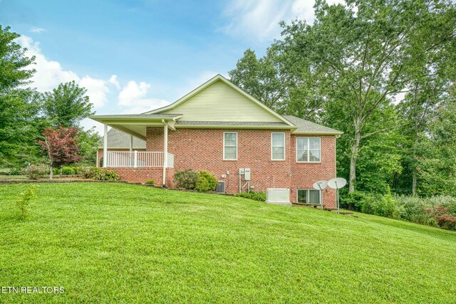 view of side of property featuring a yard and a porch