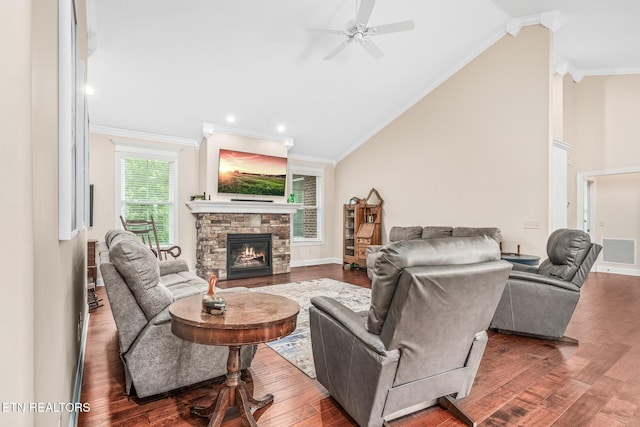 living room featuring ceiling fan, vaulted ceiling, a fireplace, dark wood-type flooring, and ornamental molding