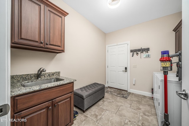 laundry room with cabinets, independent washer and dryer, and sink