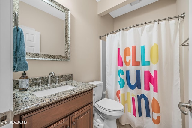 bathroom featuring toilet, vanity, and a shower with shower curtain