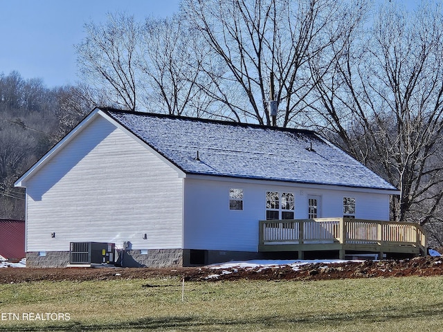 back of house with cooling unit, a deck, and a yard