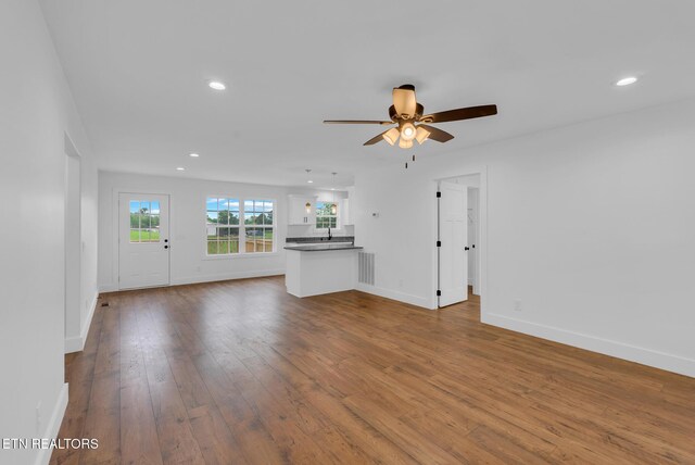 unfurnished living room with baseboards, a ceiling fan, dark wood-style flooring, and recessed lighting