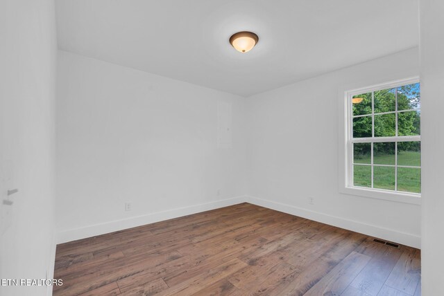 unfurnished room with baseboards and wood finished floors