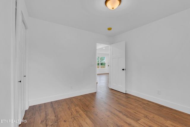 unfurnished room featuring baseboards and wood finished floors