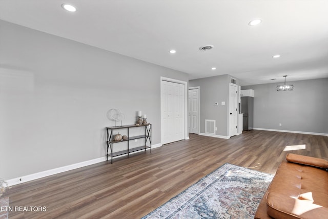 living room featuring dark wood-type flooring and a notable chandelier