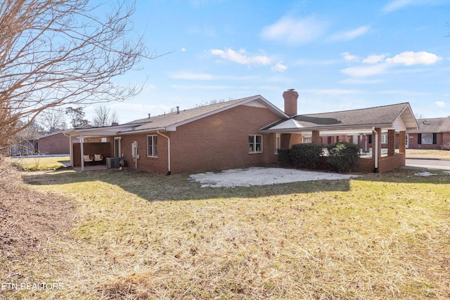 back of property with cooling unit, a patio area, and a yard