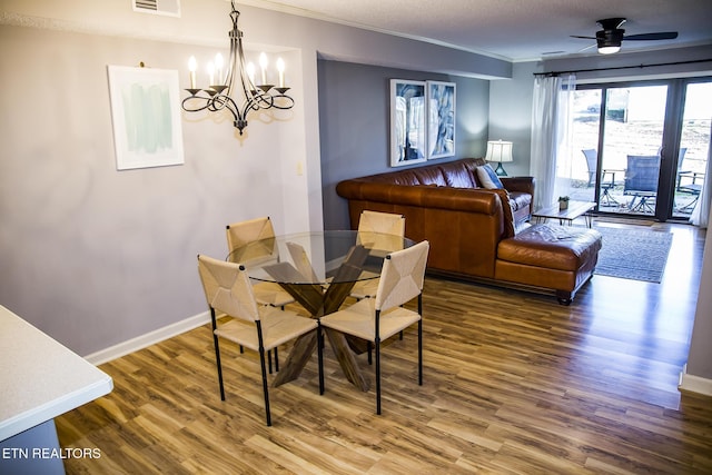 dining space featuring visible vents, ornamental molding, baseboards, and wood finished floors