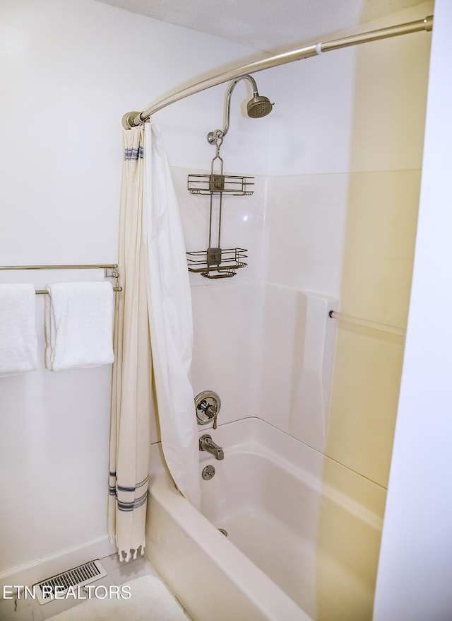 bathroom featuring tile patterned floors and shower / bath combo with shower curtain