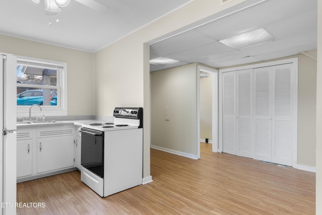 kitchen featuring light hardwood / wood-style flooring, ceiling fan, sink, white cabinets, and electric stove