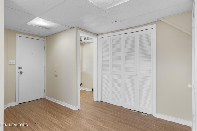 interior space with a closet, light wood-type flooring, and a paneled ceiling