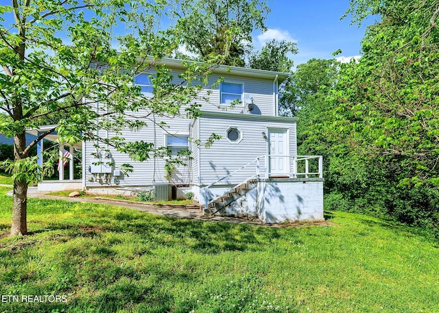 exterior space with central AC and a yard