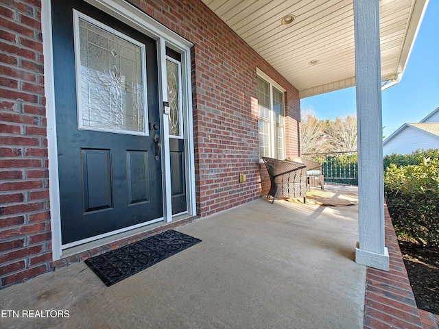 view of exterior entry featuring covered porch