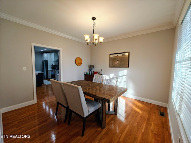 dining room with ornamental molding, dark hardwood / wood-style floors, and a chandelier