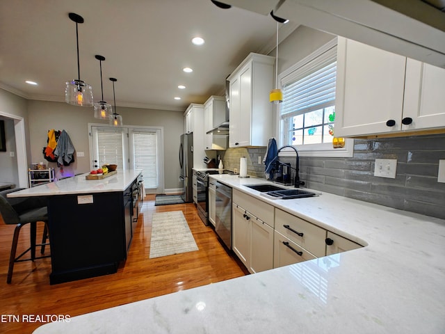 kitchen with white cabinetry, sink, and light stone countertops