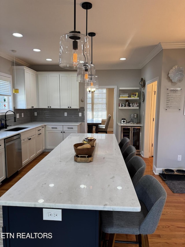 kitchen with pendant lighting, sink, dishwasher, and a kitchen island