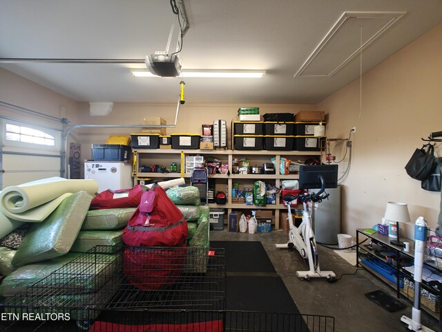 garage with a garage door opener and white fridge