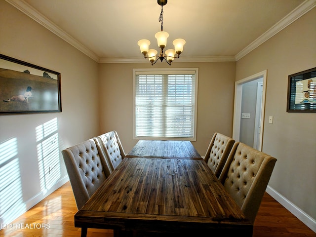 dining space with hardwood / wood-style flooring, crown molding, and a chandelier