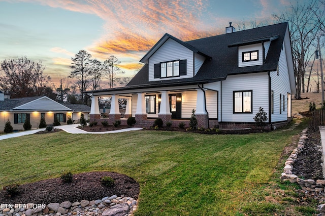 modern farmhouse featuring concrete driveway, a porch, a front lawn, and a chimney