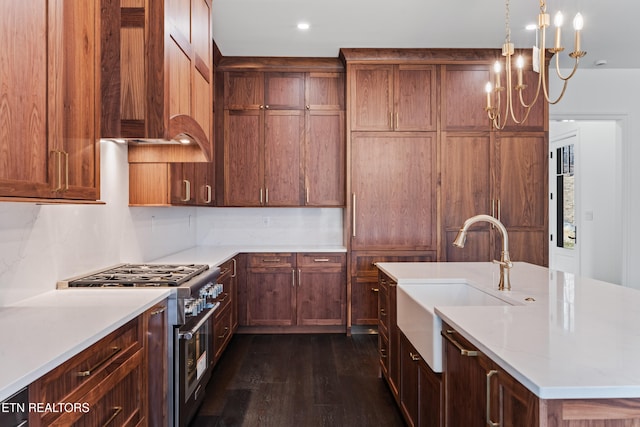 kitchen featuring dark wood-type flooring, sink, custom exhaust hood, hanging light fixtures, and high end stove