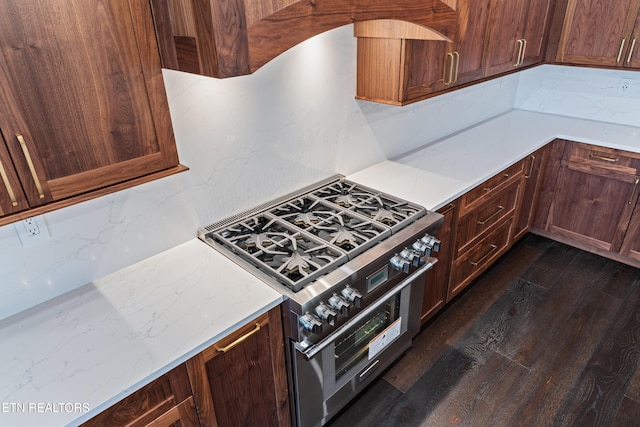 kitchen featuring tasteful backsplash, high end range, and dark hardwood / wood-style flooring