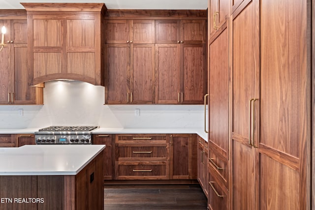 kitchen featuring decorative backsplash, dark hardwood / wood-style floors, stainless steel gas stovetop, and paneled built in refrigerator