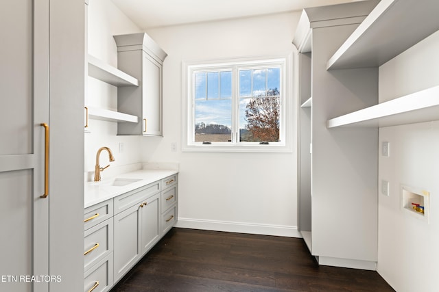 washroom featuring cabinets, washer hookup, dark hardwood / wood-style floors, and sink