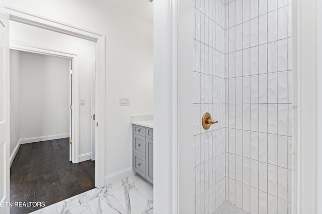 bathroom with vanity and a tile shower