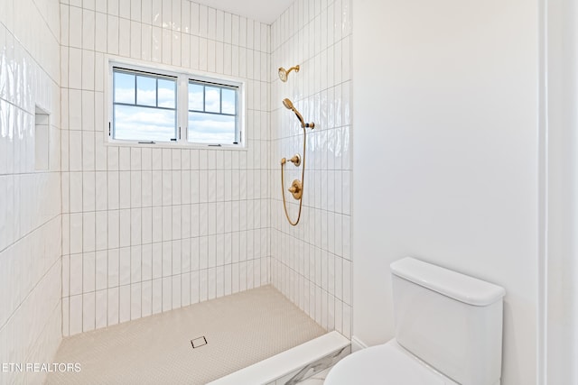 bathroom with toilet and tiled shower