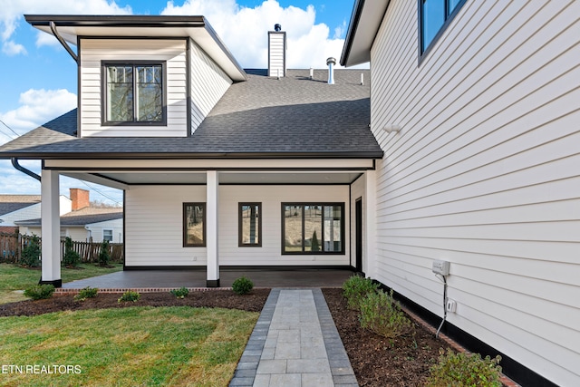 doorway to property featuring a porch and a yard