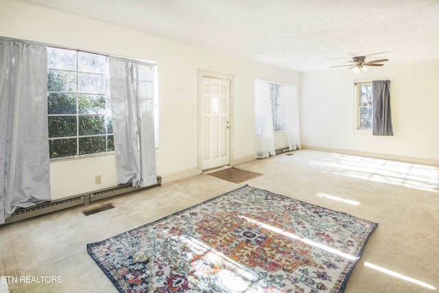 interior space featuring ceiling fan, baseboard heating, a textured ceiling, and ornamental molding