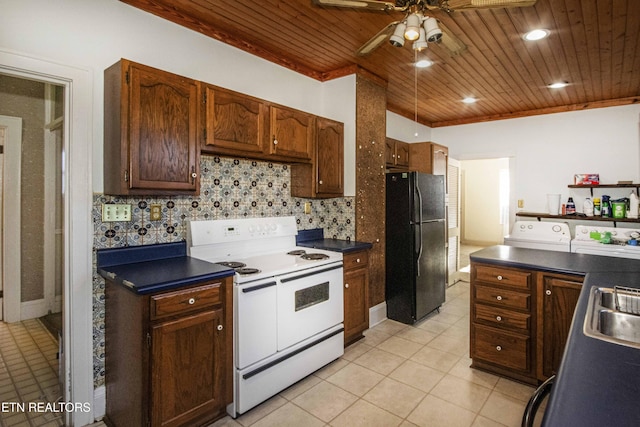 kitchen featuring double oven range, wooden ceiling, tasteful backsplash, black fridge, and washing machine and dryer