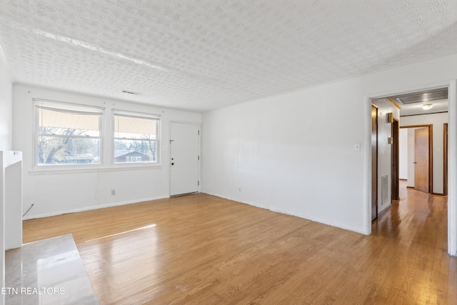 spare room with a textured ceiling and wood-type flooring