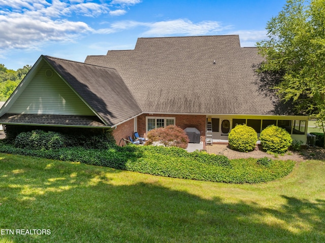 rear view of property featuring a patio area and a yard