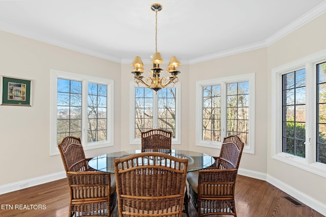 dining area with an inviting chandelier, ornamental molding, and dark hardwood / wood-style floors