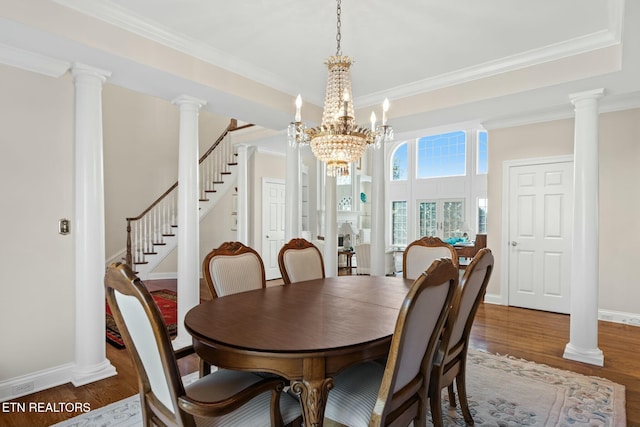 dining room featuring ornamental molding, dark hardwood / wood-style flooring, decorative columns, and a notable chandelier