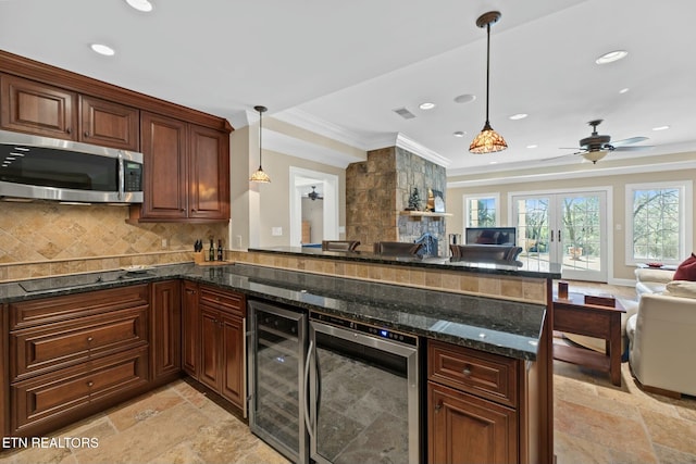 kitchen featuring pendant lighting, black electric stovetop, beverage cooler, and kitchen peninsula